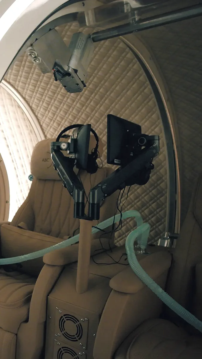 Chamber seats with oxygen mask tubing and monitors between sessions