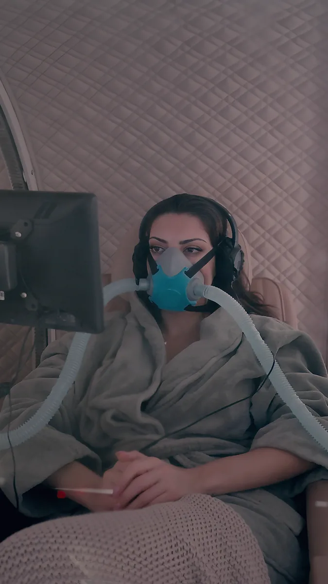 A guest wearing headphones and an oxygen mask during a 65 minute session at 2.0 ATA